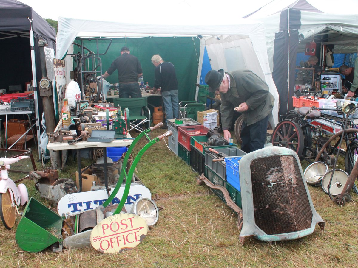 A parts vendor's stand at an autojumble, with a radiator shell and used parts on the grass. Photo: Aliimagic, CC BY-SA 4.0, via Wikimedia Commons